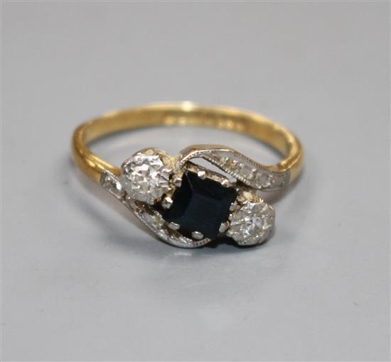 A modern 18ct gold, sapphire and illusion set diamond three stone crossover ring, size L, gross weight 3.5 grams.